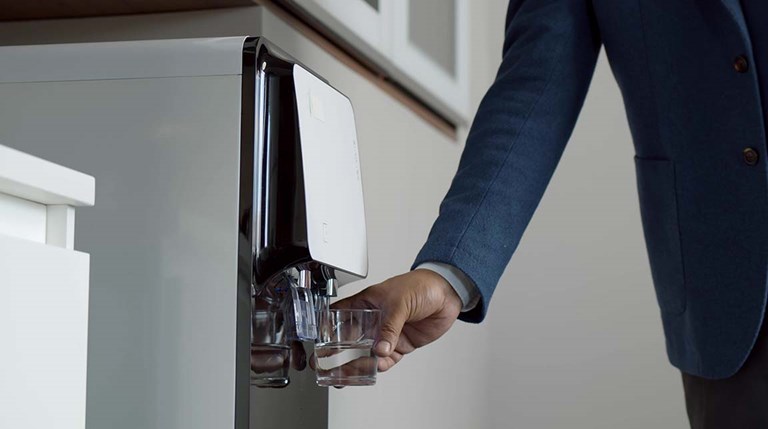 Business man filling up a plastic cup at a water fountain 