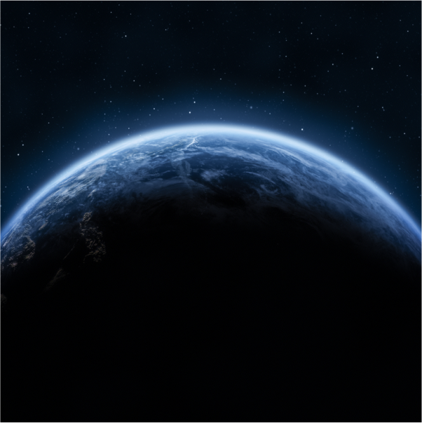 Half-shadowed view of Earth from orbit with a faint sunrise glow. 