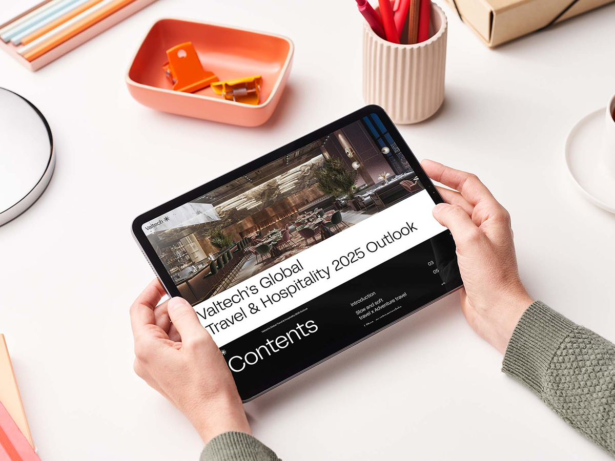 Person holding a tablet displaying Valtech’s Global Travel & Hospitality 2025 Outlook, highlighting industry trends and digital transformation insights.