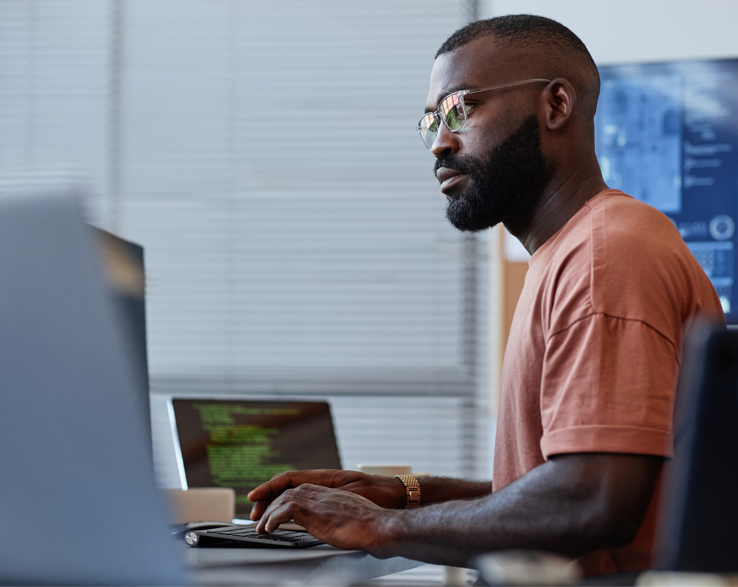 Focused man with glasses working on a computer in an office