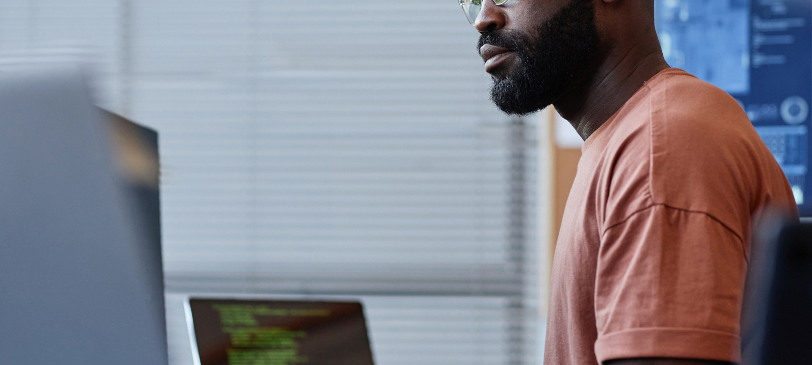 Focused man with glasses working on a computer in an office
