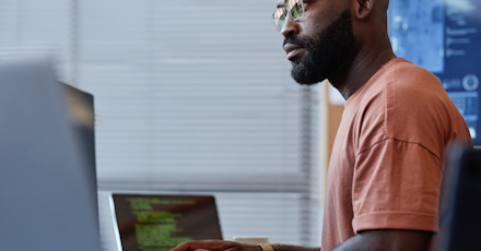Focused man with glasses working on a computer in an office