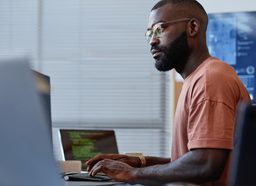 Focused man with glasses working on a computer in an office