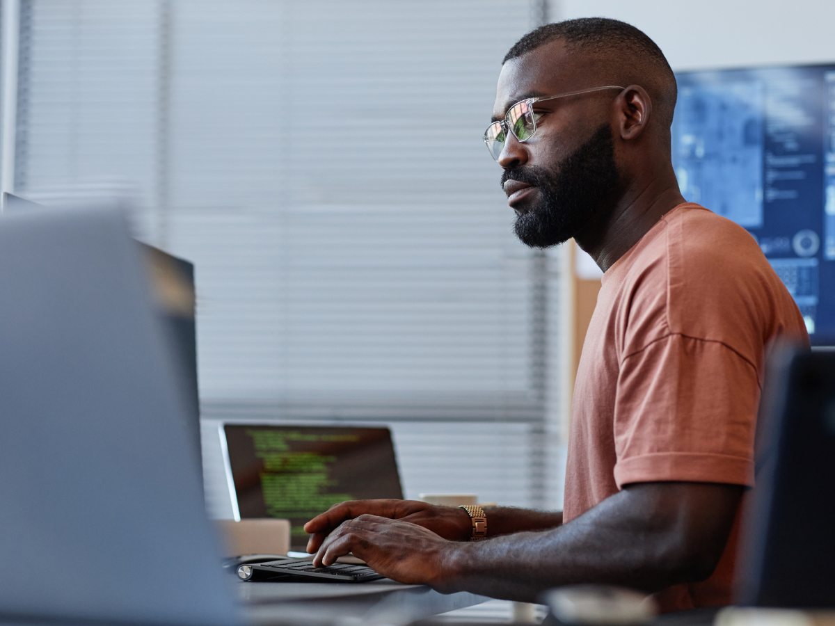 Focused man with glasses working on a computer in an office