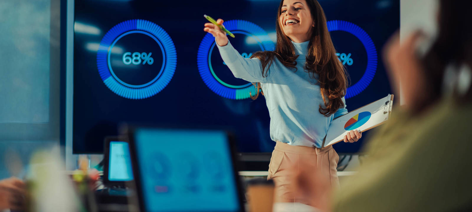 Confident businesswoman presenting data analytics to a team, showcasing leadership and effective communication
