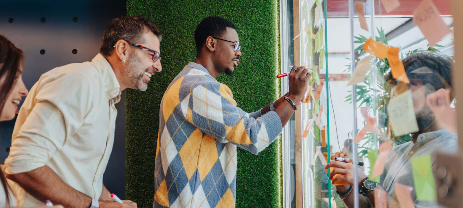 Diverse team collaborating on a project using sticky notes and markers in a creative workspace.