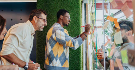 Diverse team collaborating on a project using sticky notes and markers in a creative workspace.