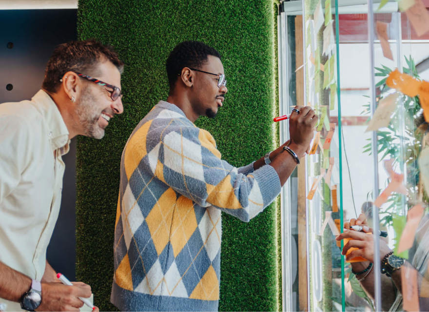 Diverse team collaborating on a project using sticky notes and markers in a creative workspace.