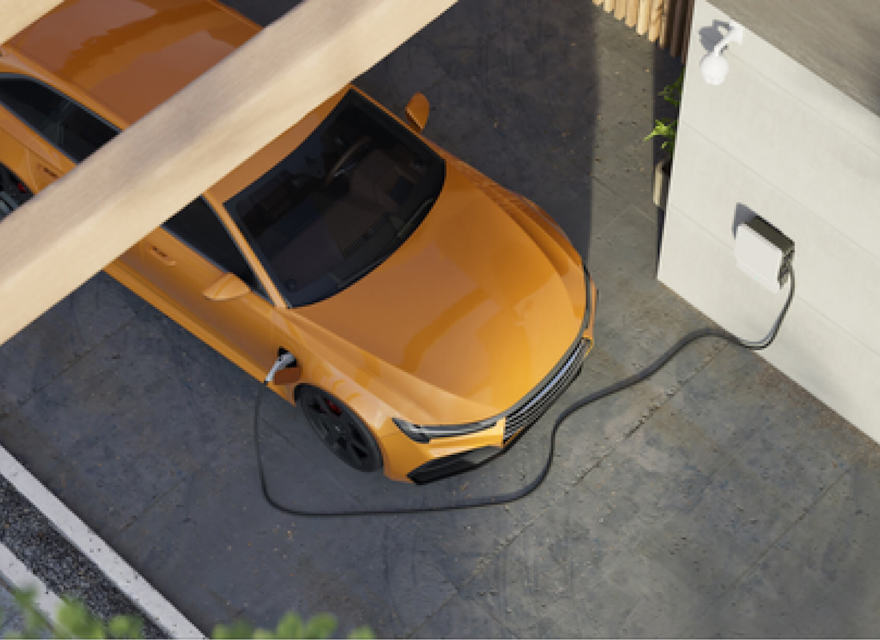 A top-down view of an orange electric car charging at a home charging station. The car is parked in a driveway, connected to a wall-mounted charging unit. The setting is modern and clean, with part of the car shaded by a wooden structure. The image highlights sustainability and the use of electric vehicles in residential environments.