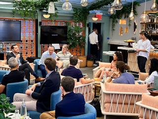 A group of people enjoying a meal together, sitting in chairs at a cozy restaurant.