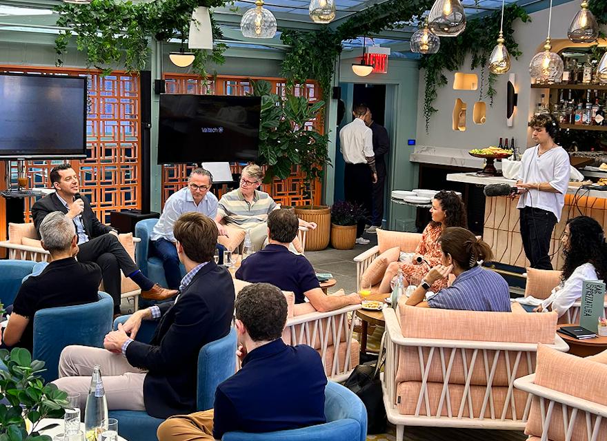 A group of people enjoying a meal together, sitting in chairs at a cozy restaurant.