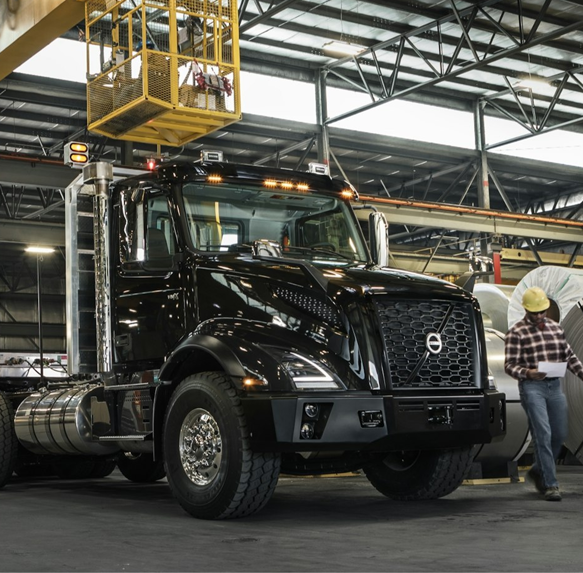 A large truck parked inside a spacious warehouse, surrounded by shelves and boxes