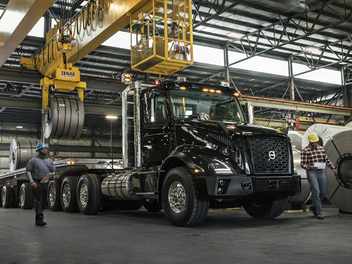 A large truck parked inside a spacious warehouse, surrounded by shelves and boxes