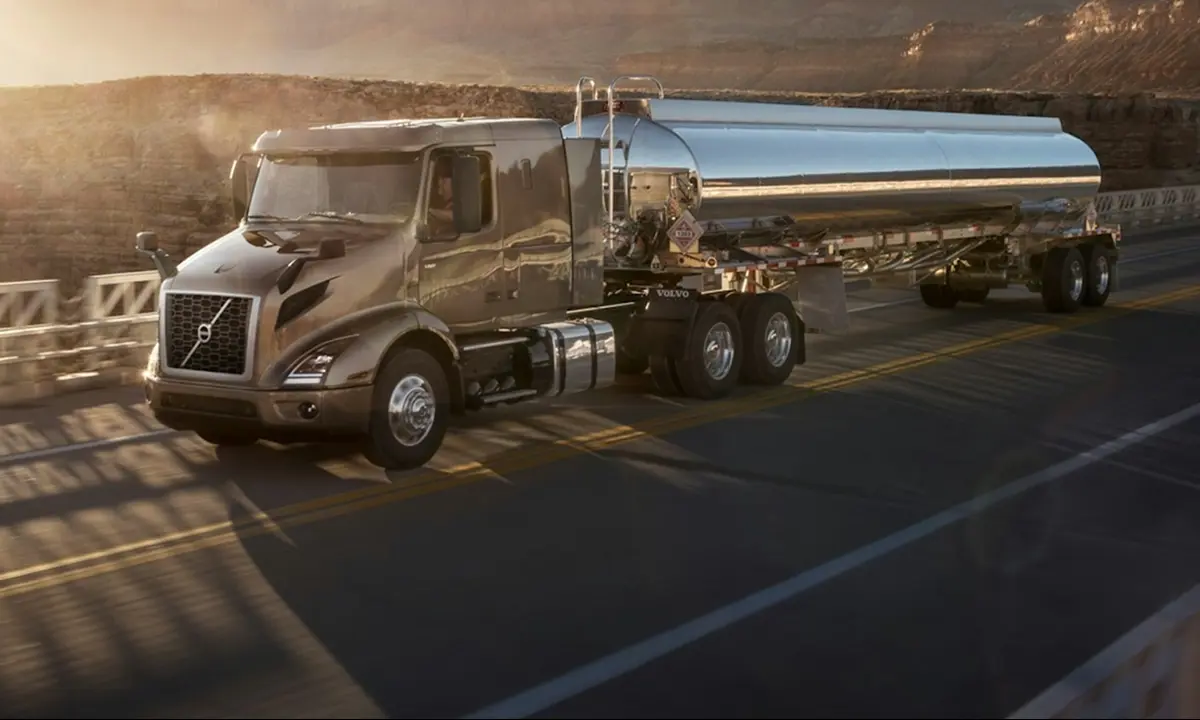 A large truck, surrounded by field and mountains