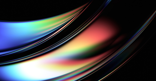 An abstract image featuring smooth, flowing curves with a spectrum of vibrant colors, including blues, greens, reds, and yellows. The glossy, reflective surface of the shapes creates a sense of depth and movement, with the colors blending and transitioning seamlessly. The background is dark, which enhances the vividness of the colors and gives the image a sleek, modern feel. This visually dynamic composition evokes a futuristic and energetic atmosphere, often associated with technology and innovation.