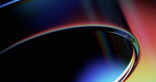 An abstract image featuring smooth, curved shapes with a gradient of vibrant colors including blue, red, and yellow, creating a sleek and dynamic visual effect.