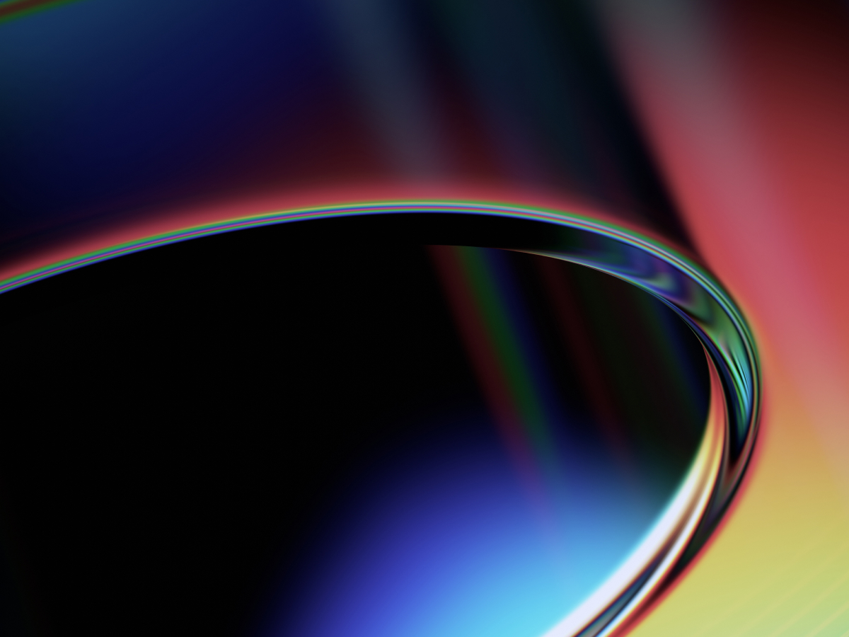An abstract image featuring smooth, curved shapes with a gradient of vibrant colors including blue, red, and yellow, creating a sleek and dynamic visual effect.