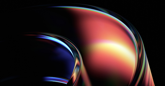 An abstract image featuring smooth, curved shapes with a glossy, reflective surface. The design transitions from rich, deep blues on the left to warm reds, oranges, and yellows on the right, creating a sense of fluid motion. The light highlights and reflections give the shapes a futuristic and dynamic feel, with the dark background adding depth and contrast. The combination of vibrant colors and sleek curves evokes innovation and cutting-edge technology.