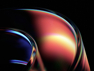 An abstract image featuring smooth, curved shapes with a glossy, reflective surface. The design transitions from rich, deep blues on the left to warm reds, oranges, and yellows on the right, creating a sense of fluid motion. The light highlights and reflections give the shapes a futuristic and dynamic feel, with the dark background adding depth and contrast. The combination of vibrant colors and sleek curves evokes innovation and cutting-edge technology.