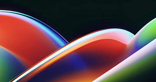 An abstract image featuring smooth, overlapping curved shapes with glossy, reflective surfaces. The colors transition from vibrant reds and oranges on the left to bright yellows, greens, and deep blues on the right.