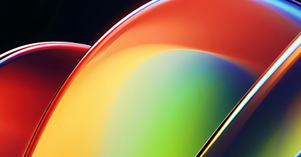 An abstract image featuring smooth, overlapping curved shapes with glossy, reflective surfaces. The colors transition from vibrant reds and oranges on the left to bright yellows, greens, and deep blues on the right. The design creates a sense of fluidity and motion, with the light reflecting off the curves to emphasize their sleek, polished appearance. The dark background enhances the bright, bold colors, giving the image a modern and dynamic feel, often associated with technology and innovation.