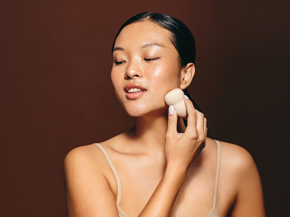 Person applying makeup sponge to jawline with overlay showing order issue automatically resolved.
