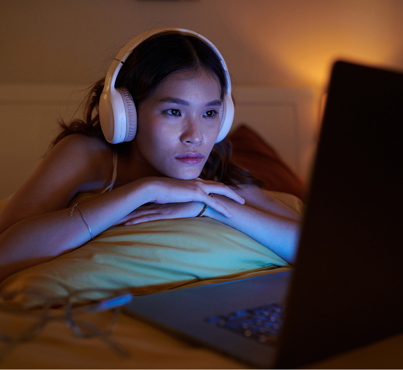 Woman wearing headphones looking in the phone