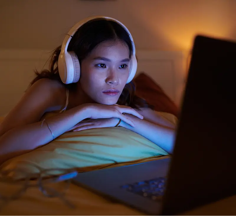 Woman wearing headphones looking in the phone