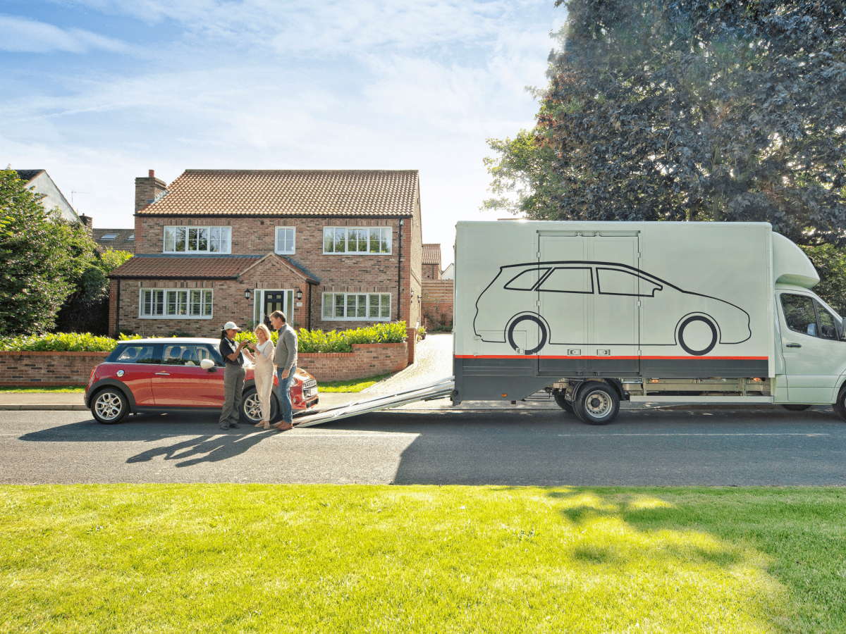 A car delivery scene in a suburban neighborhood, where a couple is receiving their red Mini Cooper. 