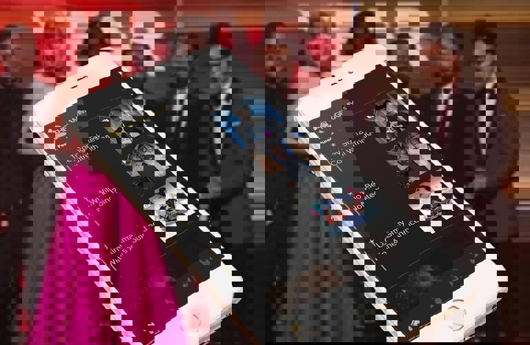 Background of Taylor Swift and others accepting a Grammy, foreground of a cellphone screen showing the home page of the app which includes a list of features news bites