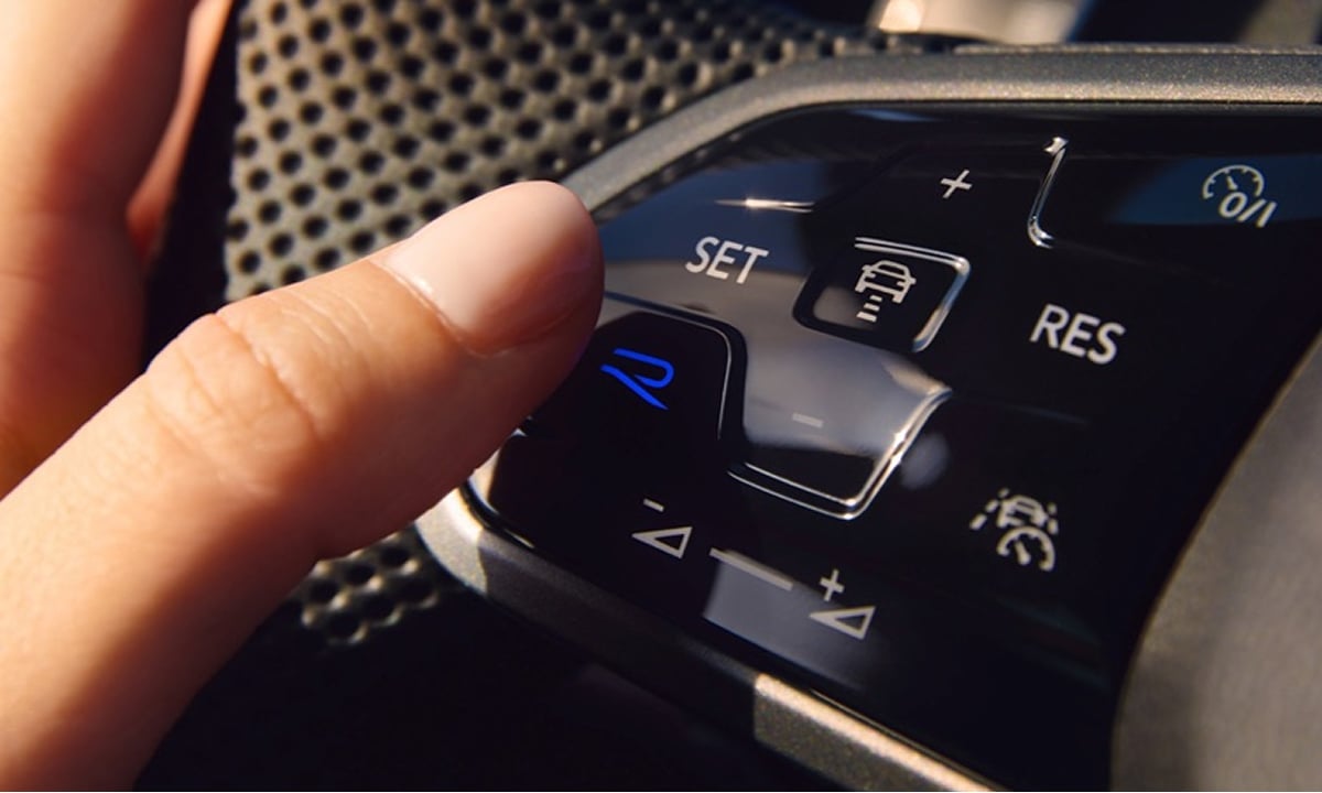Aerial view of a car navigating a winding road through a scenic landscape.