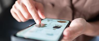 Close-up of a person browsing an online retail store on a smartphone, highlighting mobile commerce and AI-powered product recommendations.