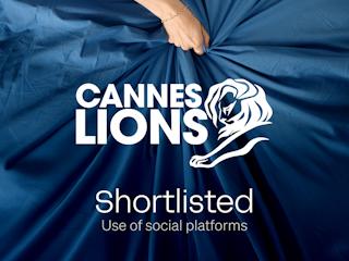 A hand pinches the center of a billowing dark-blue sheet, creating dramatic folds. Overlaid in bold white lettering are the Cannes Lions lion logo and the words “CANNES LIONS,” followed by the caption “Shortlisted – Use of social platforms” and the campaign title “Just Give a F*ck – RFSU” in the lower corner.