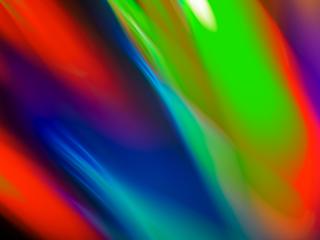 A vibrant and colorful abstract background with gradients of red, green, blue, and purple, blending smoothly with reflections, representing a dynamic and modern design.