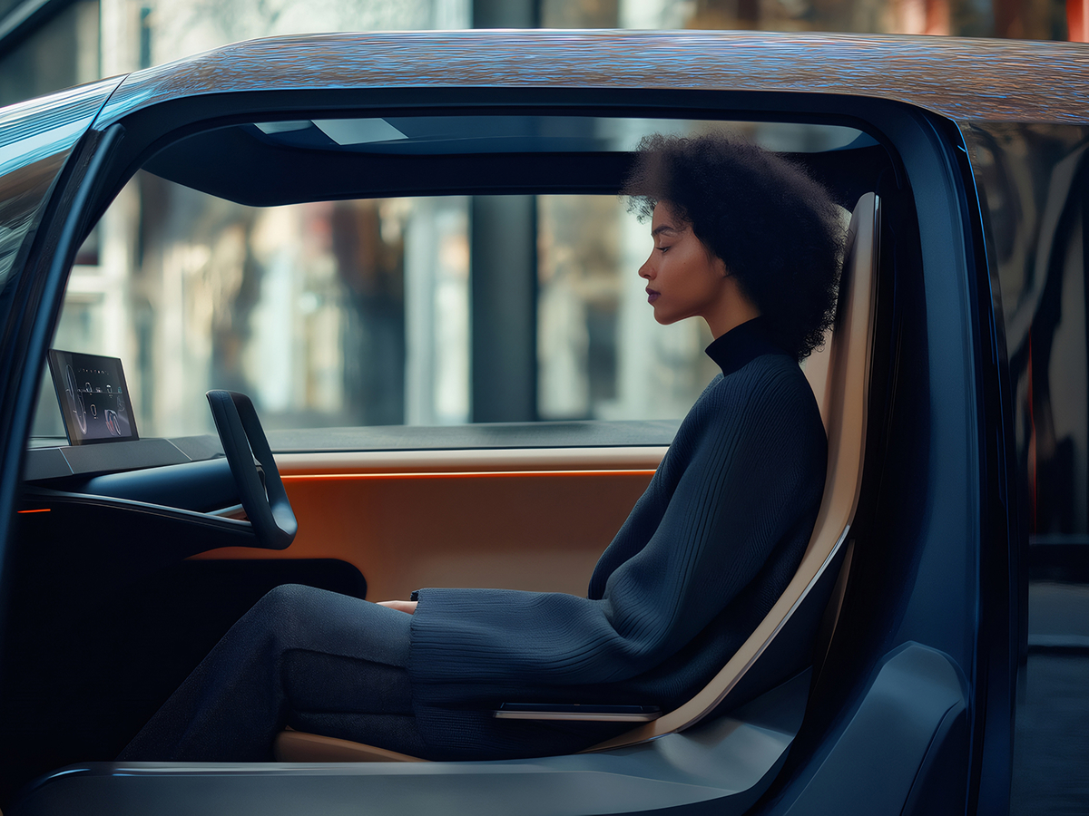 A woman seated in the driver's seat of a car, focused on the road ahead.
