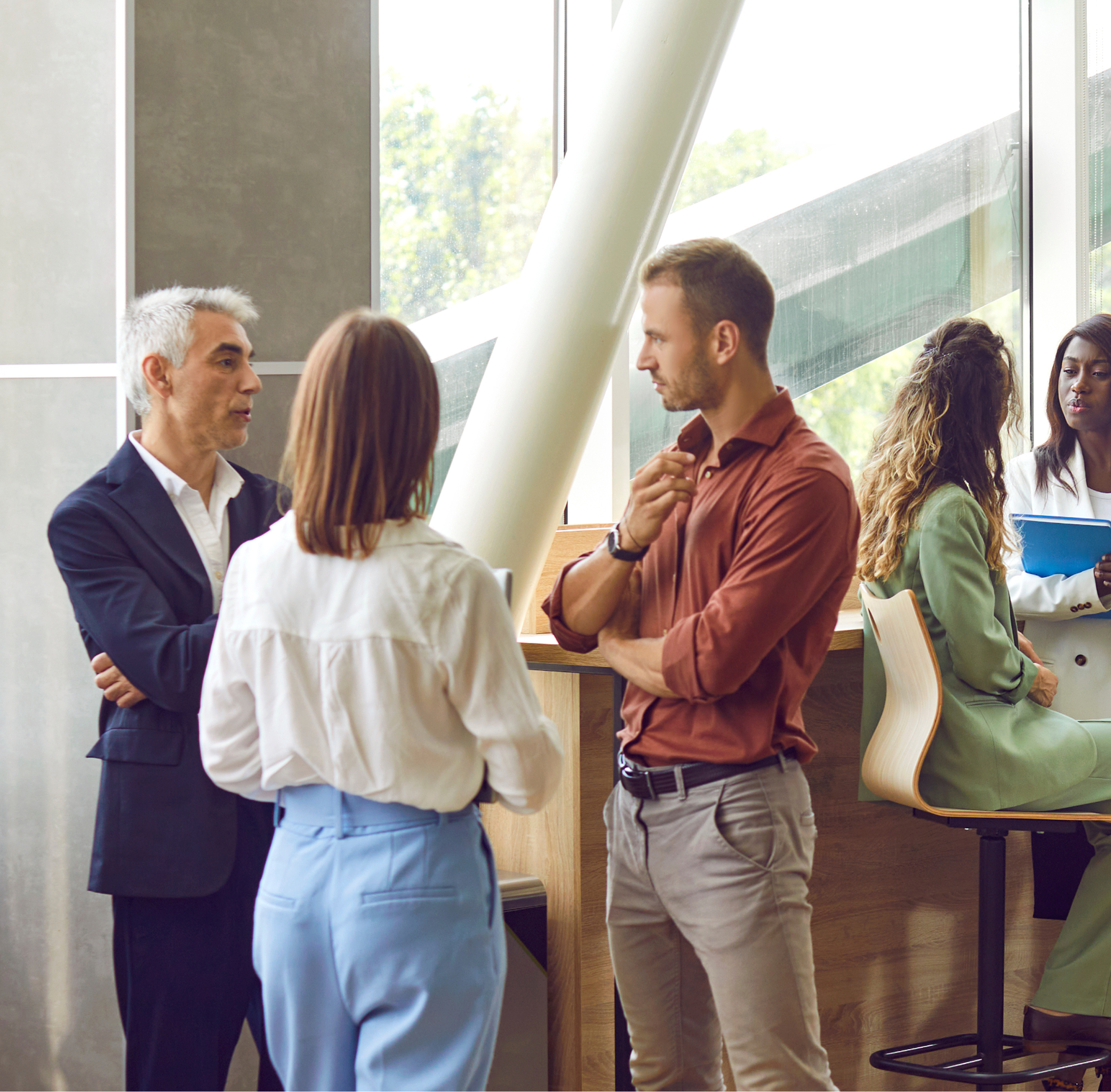A group of professionals are having conversations in a modern office.