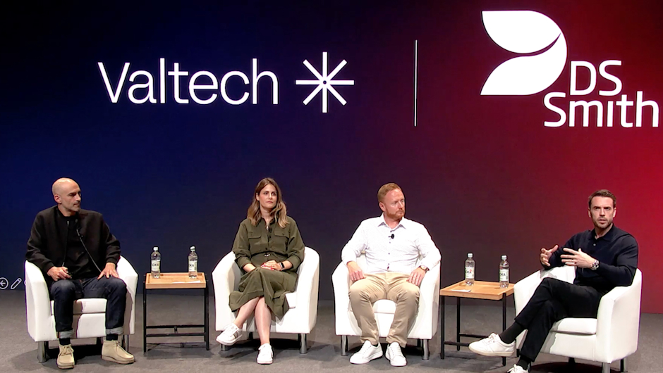 A panel of four professionals speaking at a Valtech and DS Smith event, seated on stage with logos in the background, discussing digital transformation.
